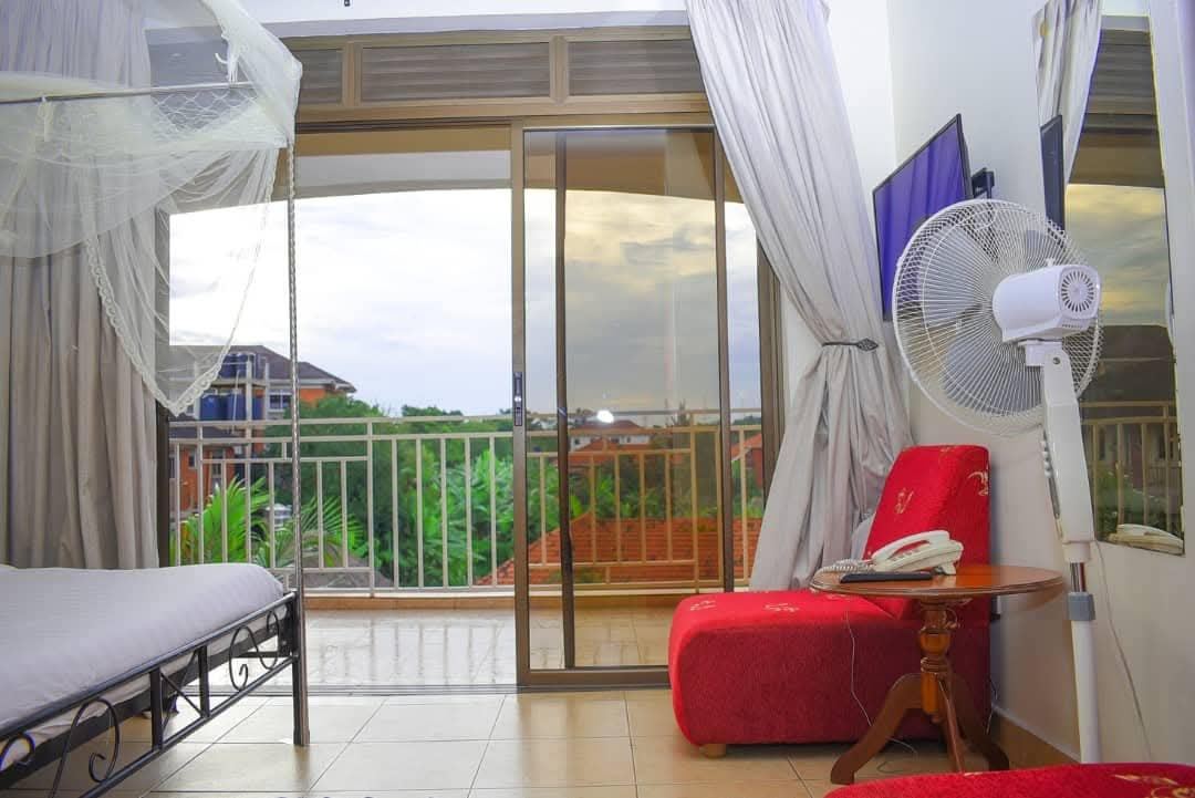 Sky Hotel room with mosquito-net bed, balcony doors, TV and fan